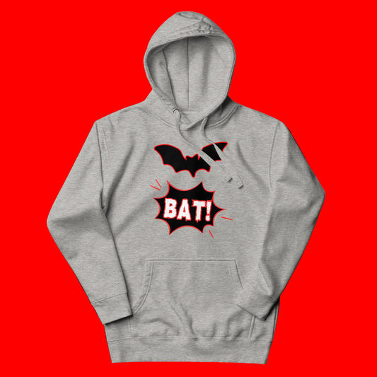 A heather gray pullover hoodie featuring a graphic print of a black bat silhouette above a red comic-style speech bubble with the word 'BAT!' in white, shown on a plain white background.