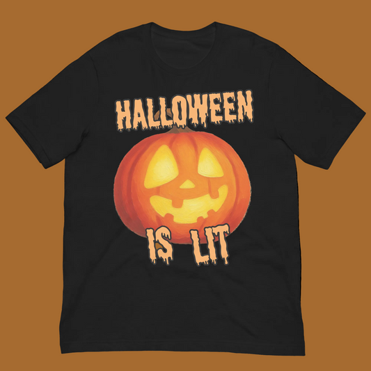 A black short-sleeve crewneck t-shirt featuring a Halloween graphic with a glowing orange jack-o'-lantern and the dripping text 'HALLOWEEN IS LIT' in orange and yellow.
