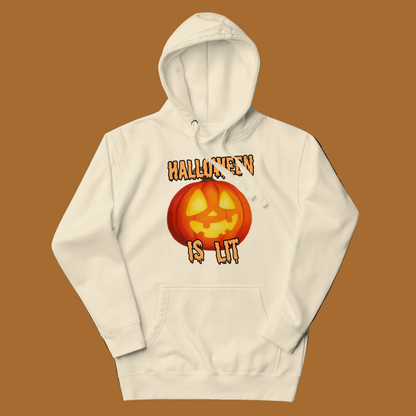 An off-white hooded sweatshirt with a graphic of a glowing jack-o'-lantern and the text 'HALLOWEEN IS lit' in orange and yellow, displayed on a clean white background.