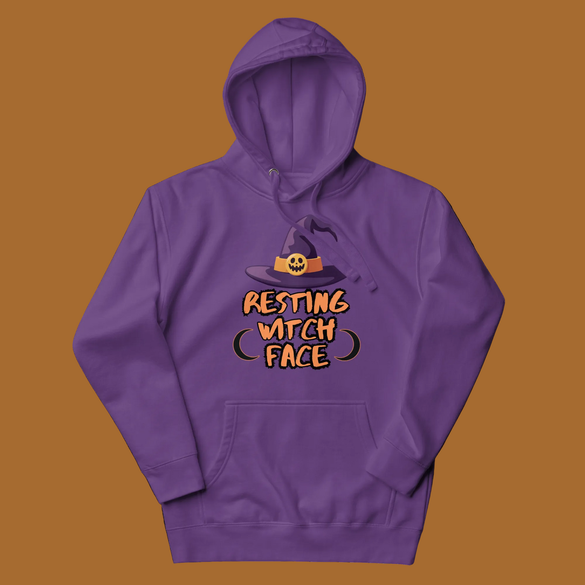 A purple pullover hoodie with a graphic on the chest showing a witch hat above the text 'RESTING WITCH FACE' in orange and black, displayed on a clean white background.