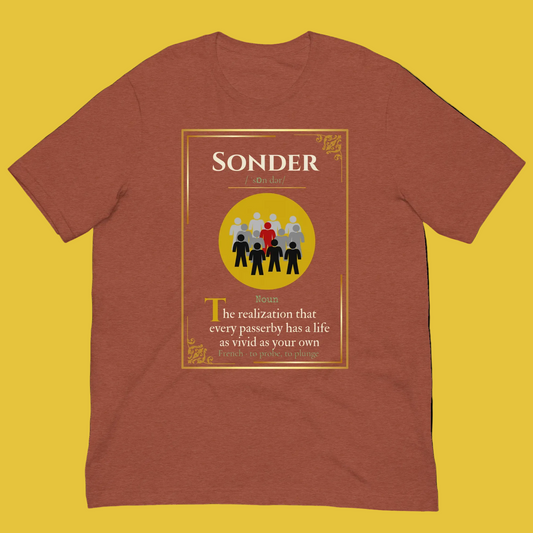 A heathered rust-brown short-sleeve t-shirt with a graphic print on the front. The graphic features a yellow border and a central yellow circle containing black and red figures, with the word 'SONDER' at the top and a definition of the word printed below.