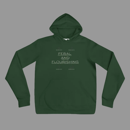 A dark green pullover hoodie with a front kangaroo pocket and a light gray graphic text print reading 'FERAL AND FLOURISHING' on the chest, displayed against a solid white background.