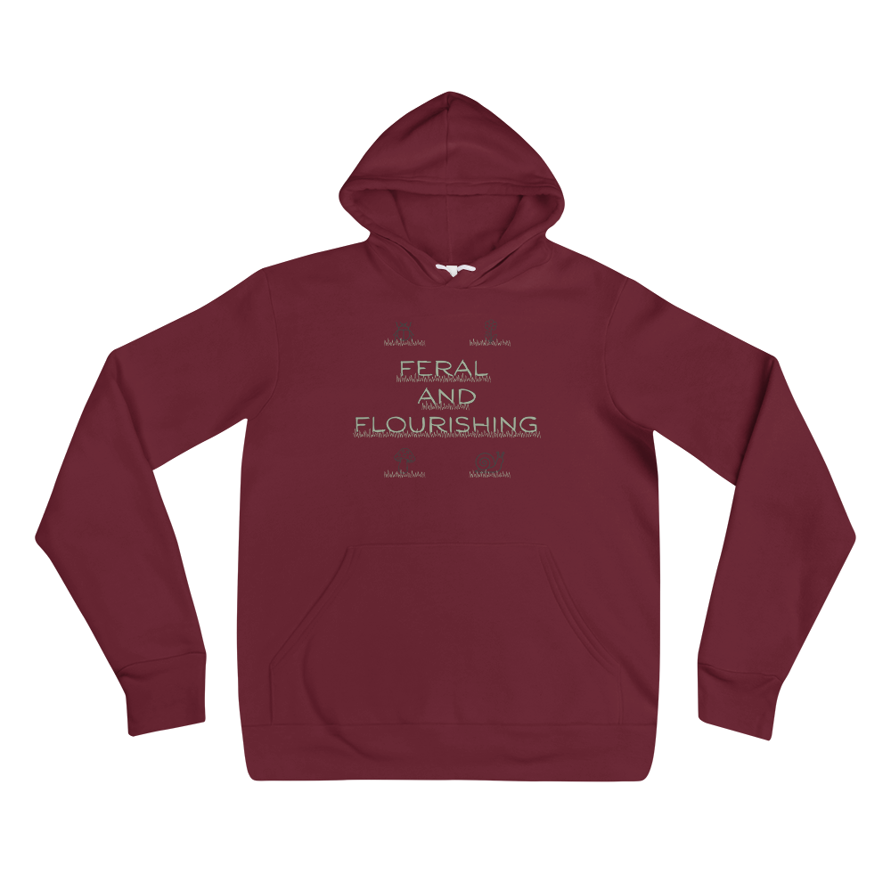 A maroon pullover hoodie with a front kangaroo pocket and a light beige graphic text print reading 'FERAL AND FLOURISHING' on the chest, displayed against a solid white background.