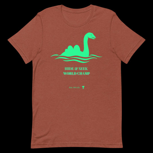 Nessie Hide and Seek World Champ cryptid graphic tee — Loch Ness Monster champion design on heather clay — Stitch and Sigil